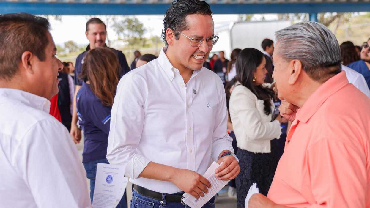 Hombre de camisa blanca estrecha la mano de una asistente junto a una mujer con camisa azul marino de Corregidora, en la jornada de salud de El Jaral.