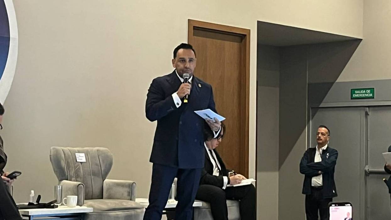 Hombre de traje azul con micrófono en un evento; Policía Estatal de Querétaro, segundo lugar nacional en confianza