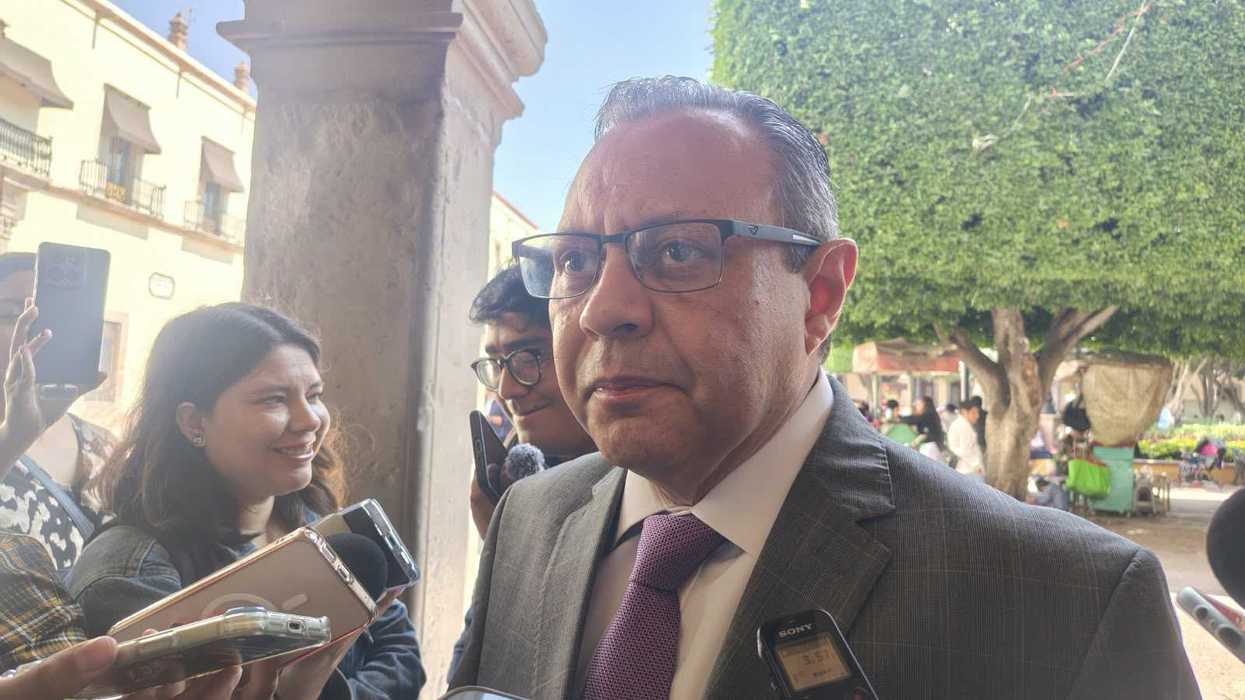 Hombre de traje gris y lentes responde a reporteros sobre el caso del adolescente de Esperanza Cabrera, en Querétaro