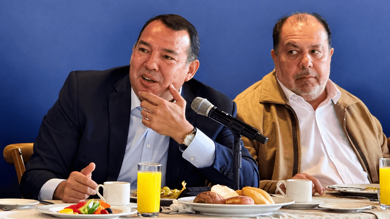 Hombre de traje oscuro habla al micrófono durante un desayuno con medios en San Juan del Río sobre el gabinete municipal y 2027.