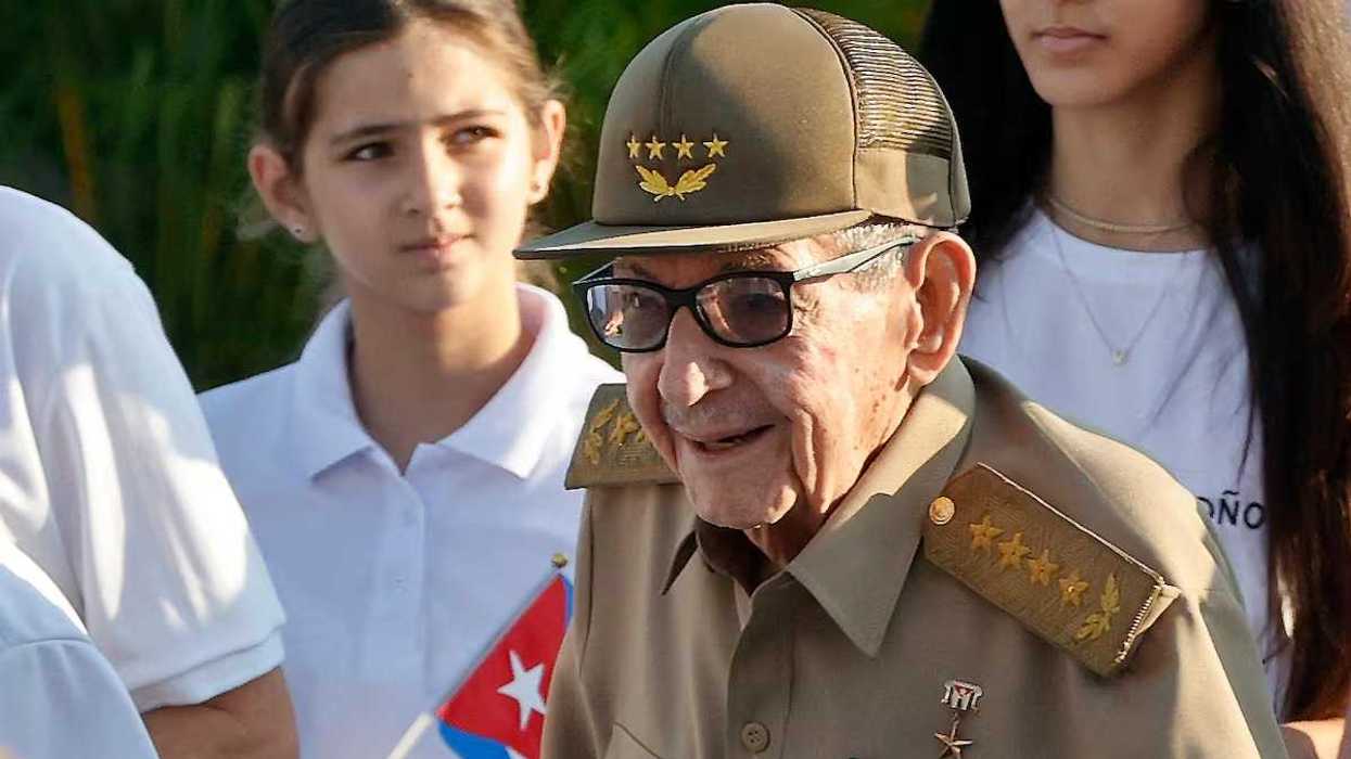 Hombre mayor con gorra y uniforme militar con estrellas, junto a jóvenes y una bandera cubana; orden de arresto en Florida