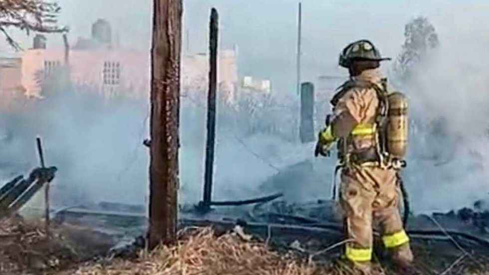 Incendio consume vivienda construida con durmientes y tarimas en colonia Insurgentes de San Juan del Río; bomberos evitan propagación a pastizales.