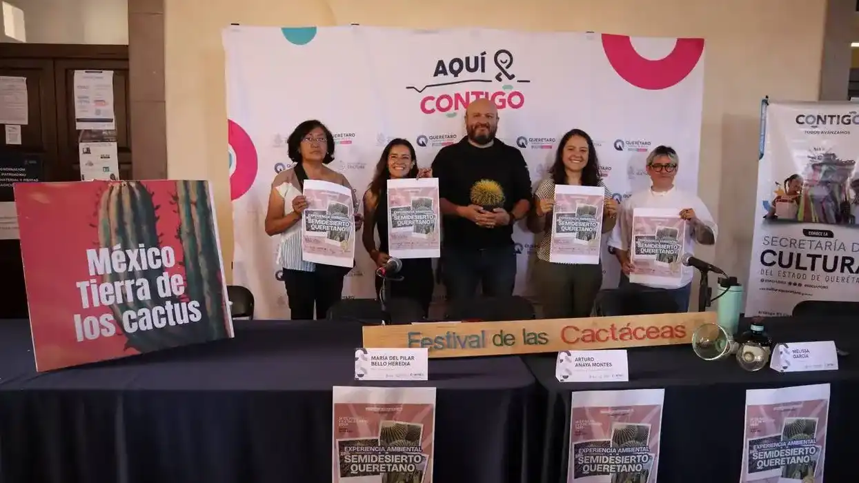 inco representantes de las organizaciones co-organizadoras sostienen carteles de la Experiencia Ambiental del Semidesierto Queretano frente al fondo del programa "Aquí Contigo" en el CEART de Querétaro.