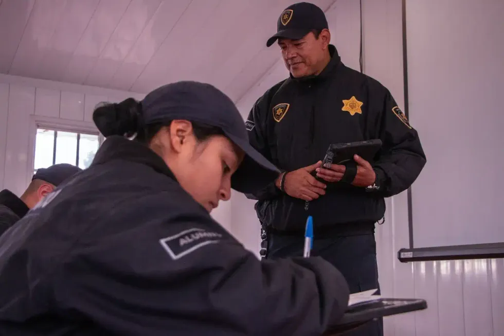 Instructor revisa una tableta junto a una alumna durante la formaci\u00f3n policial