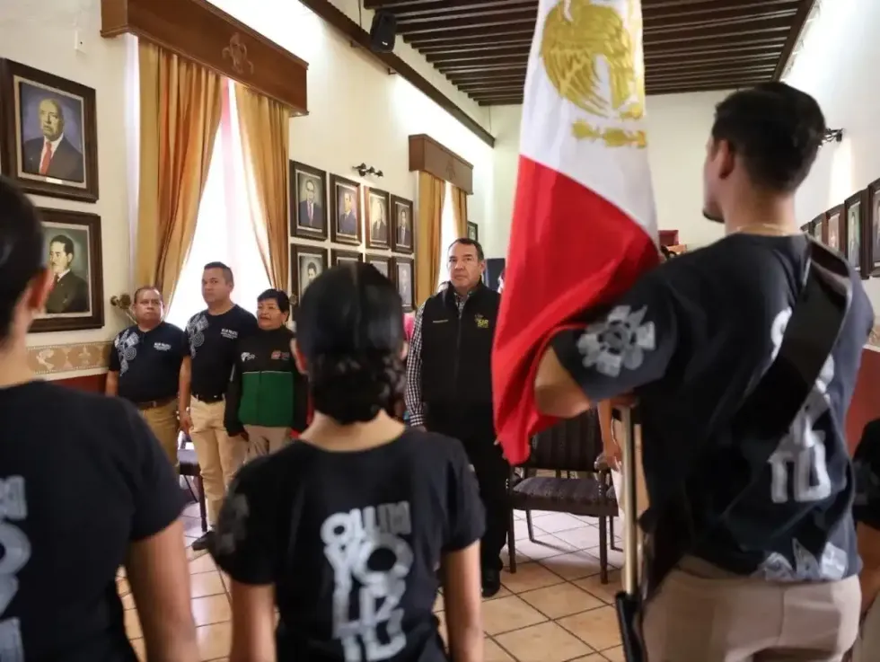 Integrante del Grupo de Danza Ollin Yoliztli porta la bandera nacional