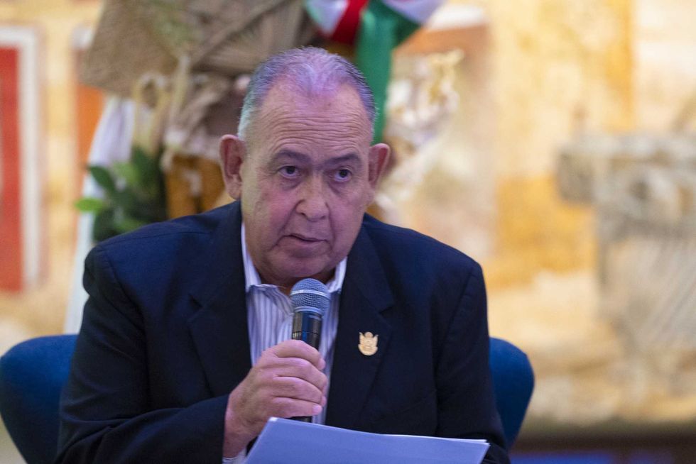 Integrante del panel de Contigo Informamos habla al micr\u00f3fono con documentos en mano durante la presentaci\u00f3n de resultados educativos