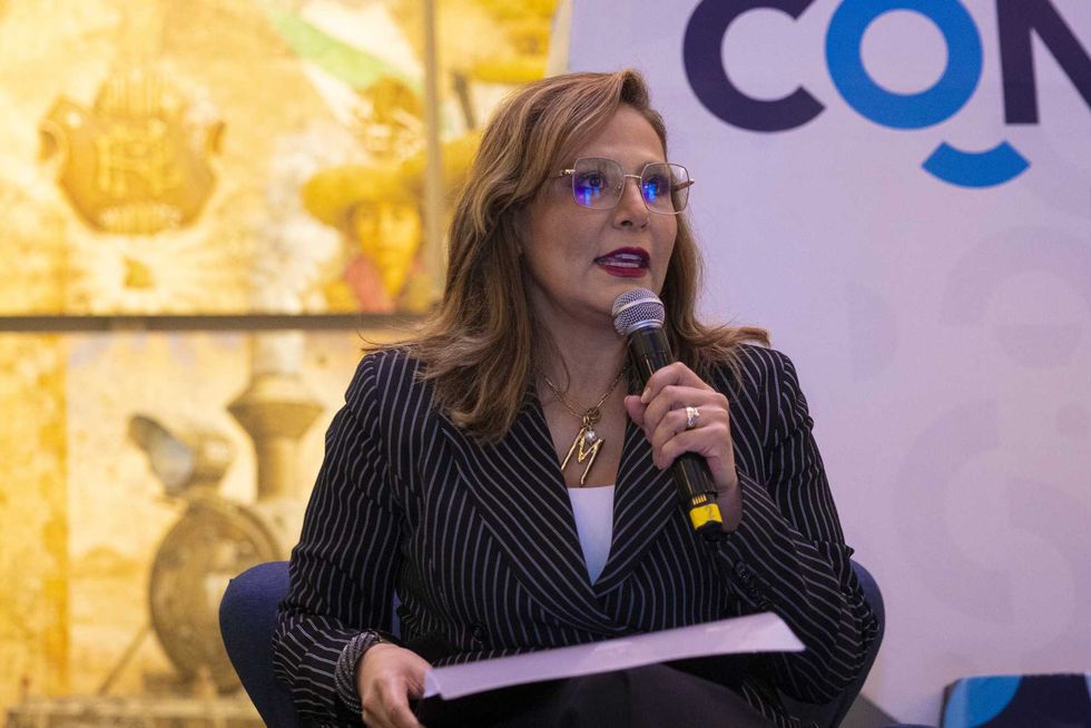 Integrante del panel habla al micr\u00f3fono frente al letrero "CONTIGO Informamos" durante la presentaci\u00f3n de resultados educativos en Quer\u00e9taro