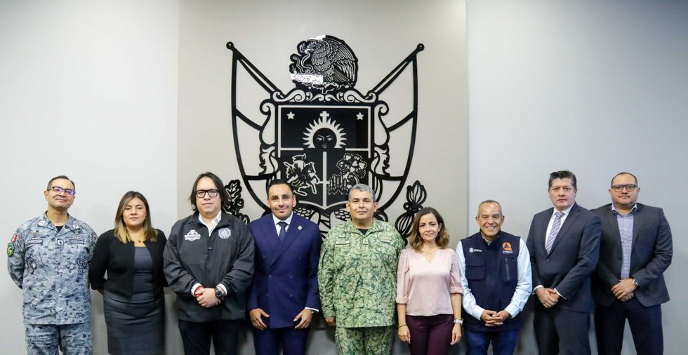 Integrantes de la Mesa Estatal de Paz posando frente al escudo del estado de Quer\u00e9taro
