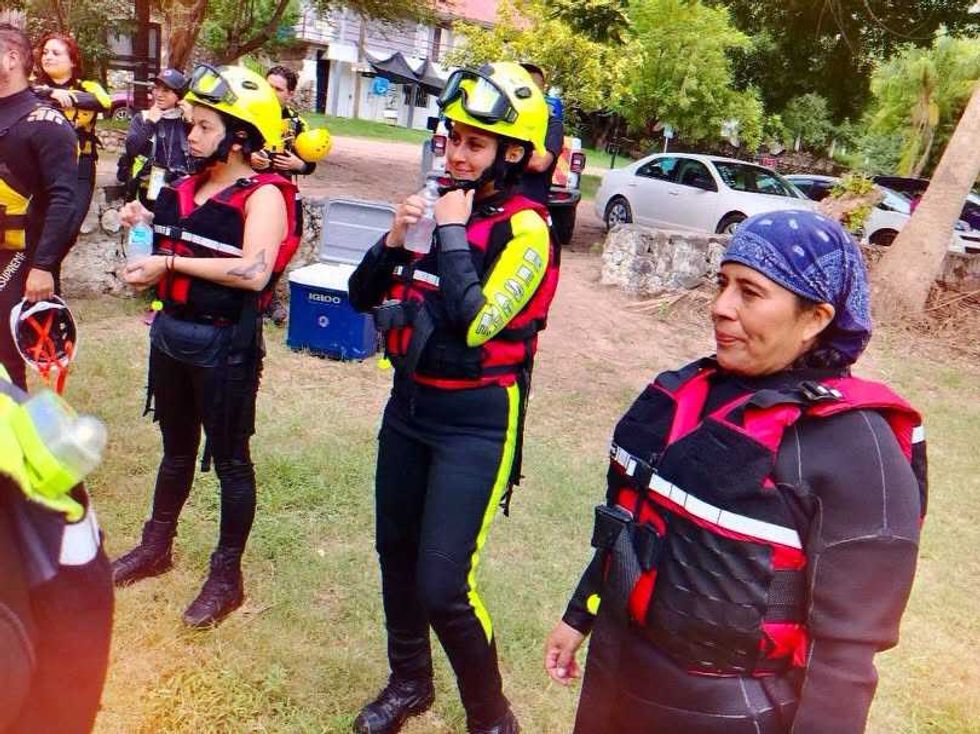 Integrantes de Protecci\u00f3n Civil con casco y chaleco salvavidas conviven al aire libre tras una jornada de capacitaci\u00f3n en rescate acu\u00e1tico.