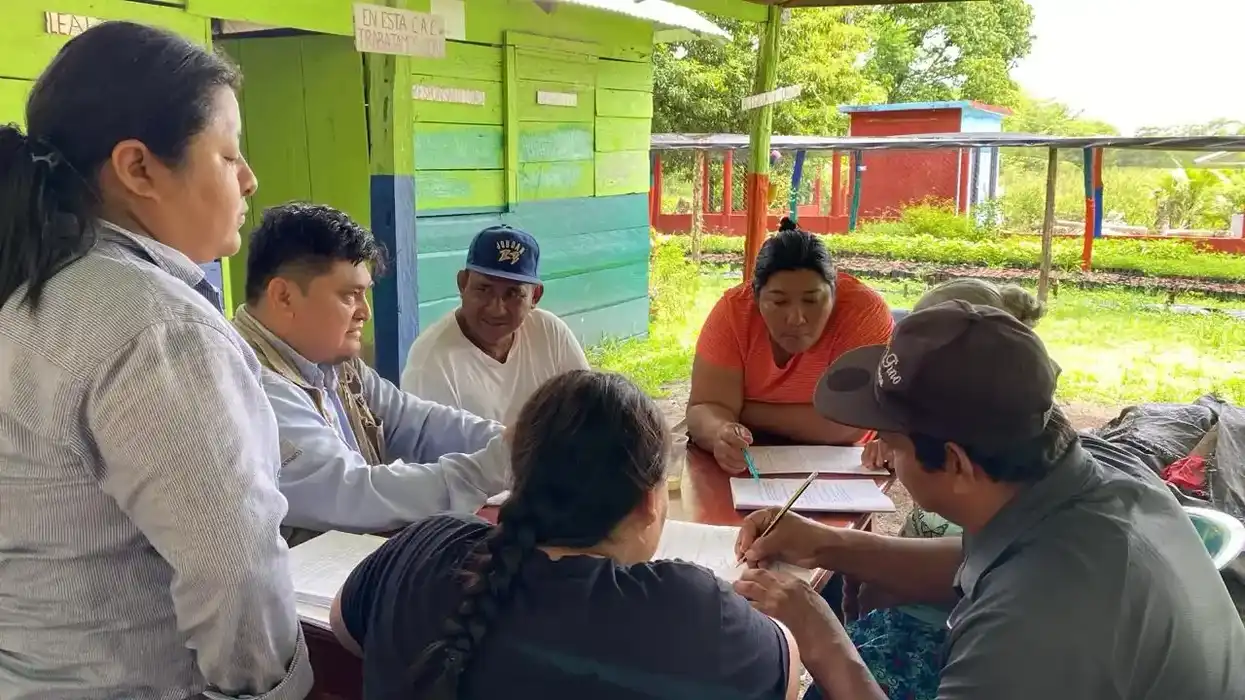 Integrantes de una comunidad rural y personal educativo posan durante una jornada de alfabetización en Chihuahua