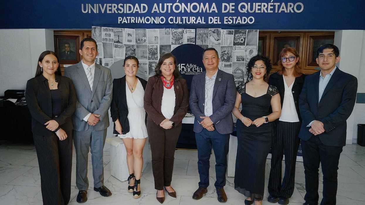 Integrantes del equipo de Gaceta UAQ y autoridades universitarias posan frente al mural conmemorativo del aniversario.