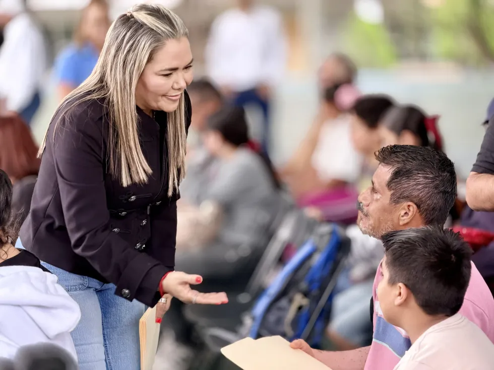 Irene Quintanar conversa con un padre de familia y un menor durante la inauguraci\u00f3n del curso de verano