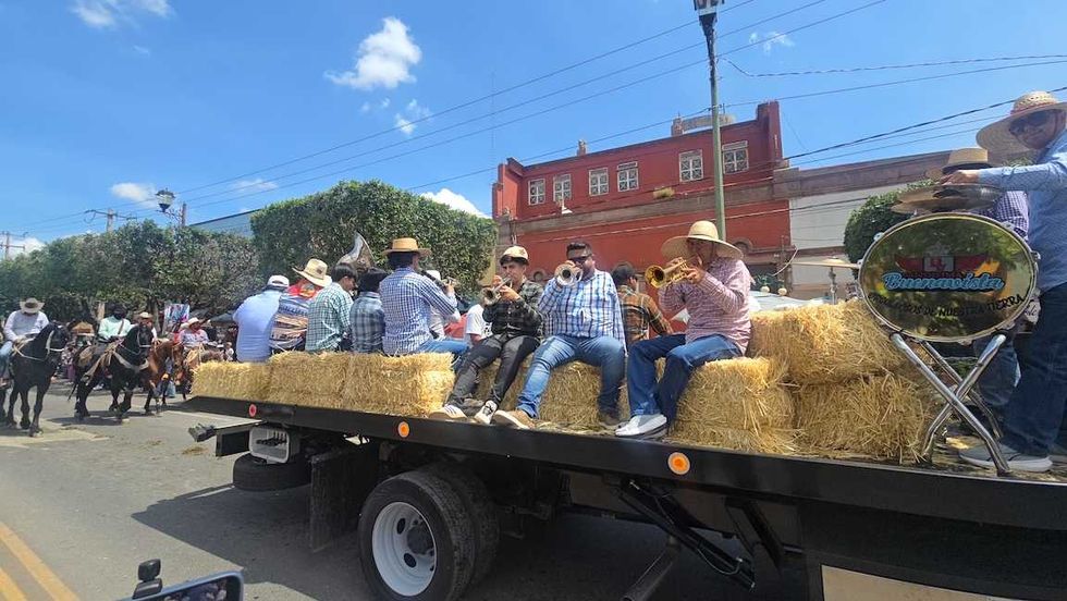 jinetes avanzan a caballo por una calle de San Juan del R\u00edo durante la Cabalgata de la Amistad.