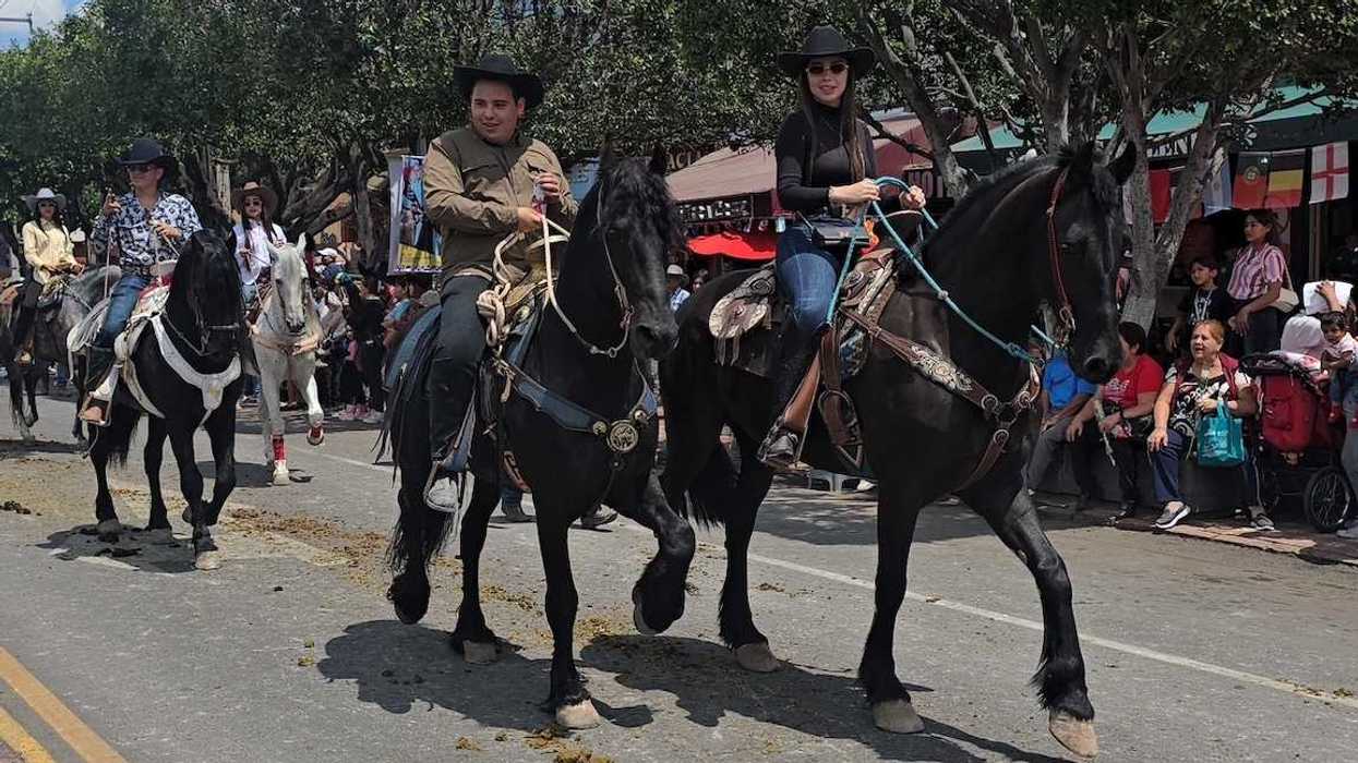 jinetes avanzan a caballo por una calle de San Juan del Río durante la Cabalgata de la Amistad.