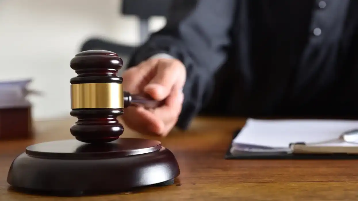 Juez sostiene un mazo sobre su mesa en sala de tribunal, con documentos al fondo, en ilustración de nota sobre sentencia por secuestro en Jacona, Michoacán.
