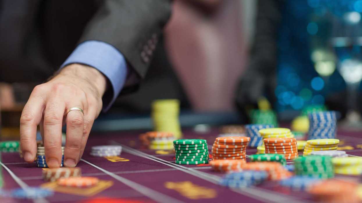 Jugador coloca fichas en una mesa de ruleta; ilustra los límites de mesa y apuestas mínimas en casino
