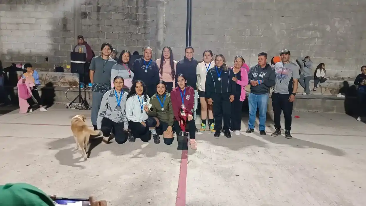 Jugadores y jugadoras posan con trofeos y medallas tras la final del torneo de básquetbol en Urecho, Colón