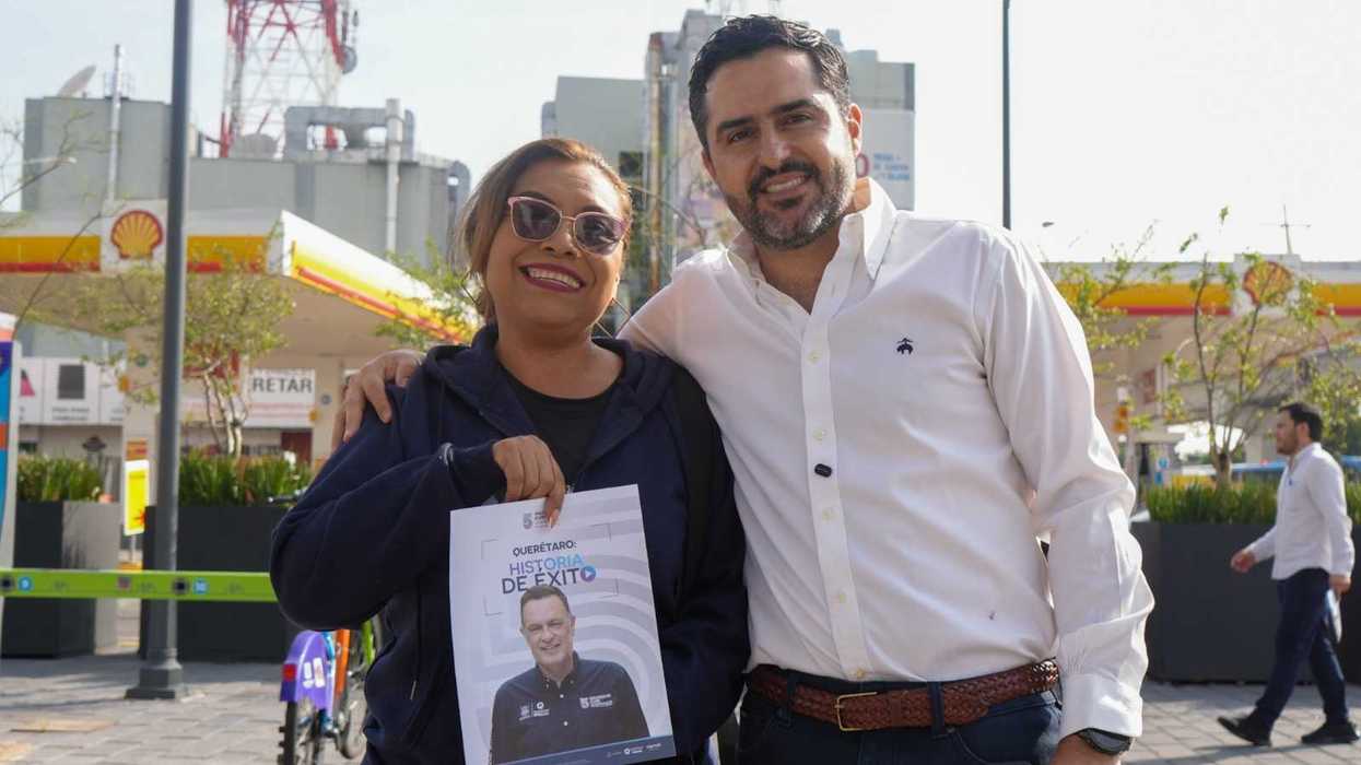 l senador Agustín Dorantes Lámbarri posa con una ciudadana que sostiene un volante del Quinto Informe de Gobierno de Mauricio Kuri durante la brigada informativa en Querétaro.