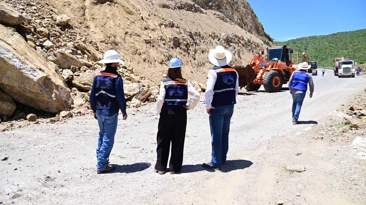 La titular de la CEI, Sonia Carrillo, y personal de la dependencia frente al talud derrumbado, con una excavadora visible en la parte superior.