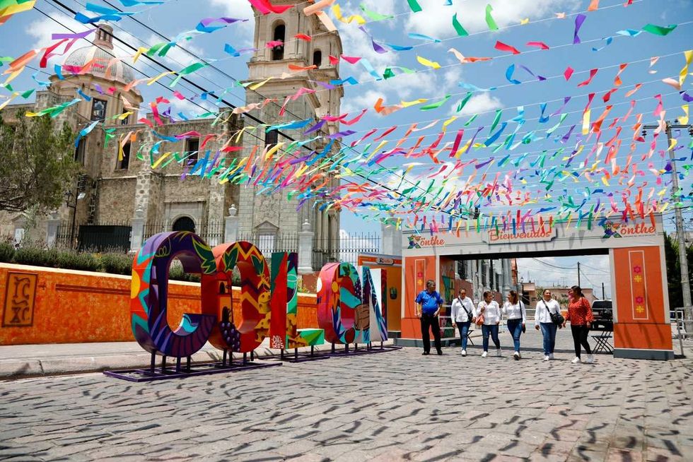 Letras monumentales de Col\u00f3n con decoraci\u00f3n de papel picado y portal del Festival X\u00f6nthe en Plaza Soriano, agosto 2026