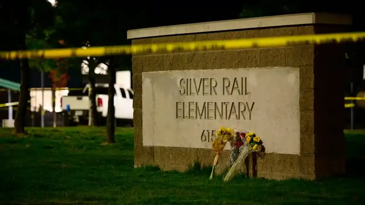 Letrero de la escuela primaria Silver Rail en Bend, Oregón, con ramos de flores y cinta policial tras el tiroteo
