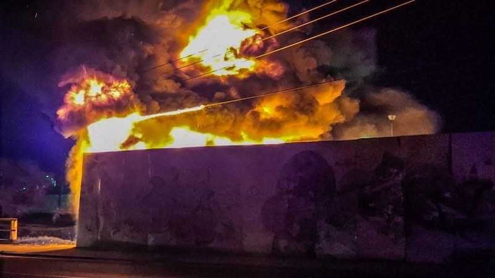 Llamas y humo negro sobresalen de predio incendiado junto a Avenida Universidad.