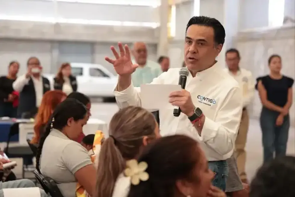 Luis Nava habla con micr\u00f3fono ante beneficiarios en bodega de Pe\u00f1amiller