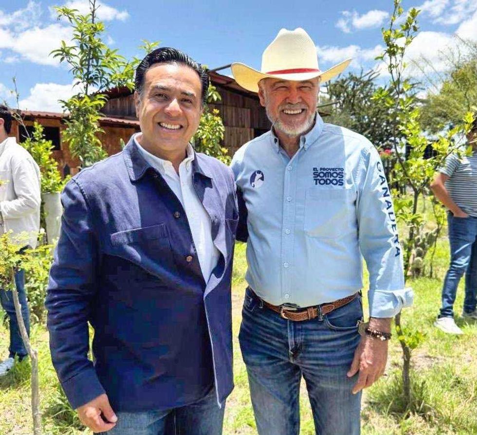 Luis Nava posa junto a un asistente con sombrero durante el encuentro en Pedro Escobedo