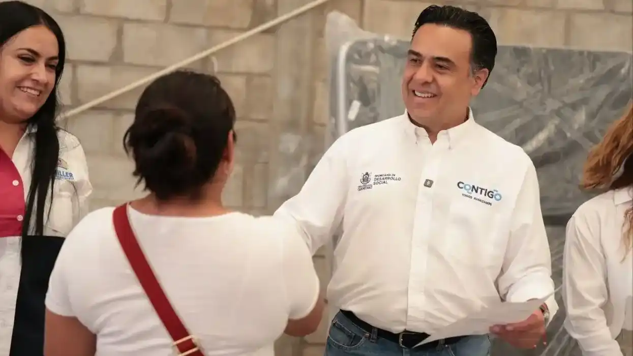 Luis Nava saluda a una beneficiaria y entrega documento en Peñamiller