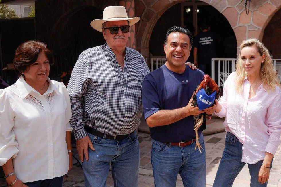 Luis Nava sostiene al gallo bautizado con su nombre, obsequiado por ejidatarios de Huimilpan.