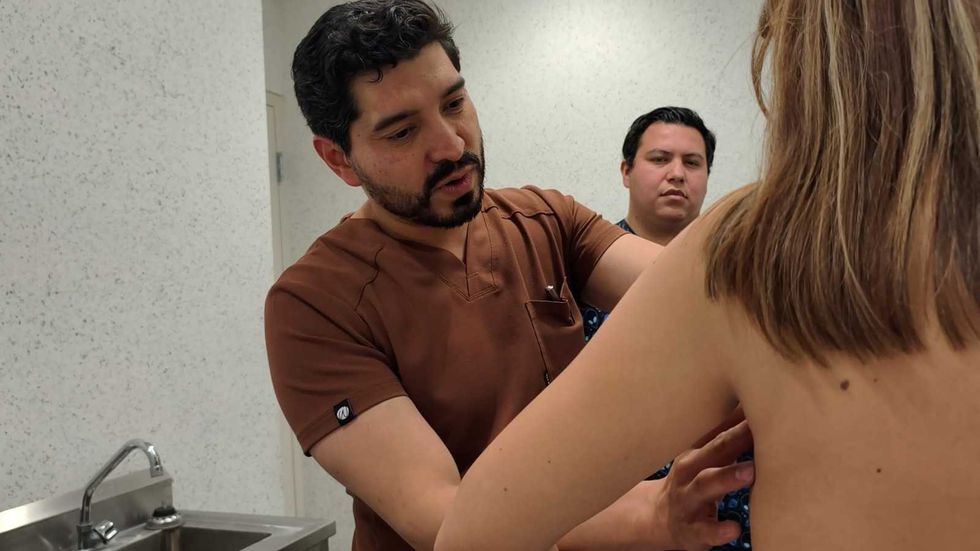 M\u00e9dico realiza exploraci\u00f3n cl\u00ednica en el HGR No. 2 del IMSS en Quer\u00e9taro como parte de la evaluaci\u00f3n preoperatoria en el programa de atenci\u00f3n a c\u00e1ncer de mama.