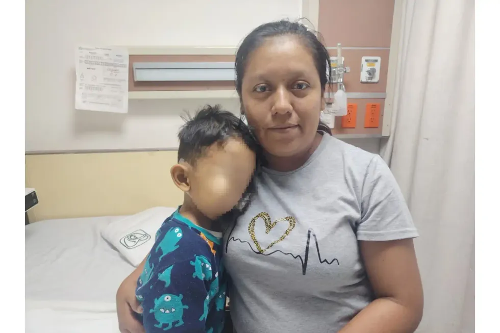 Madre abraza a su hijo, con el rostro difuminado, en una habitaci\u00f3n de hospital