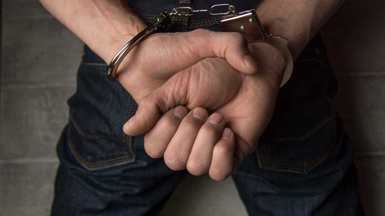 Manos de una persona detenida con esposas metálicas durante un operativo policial