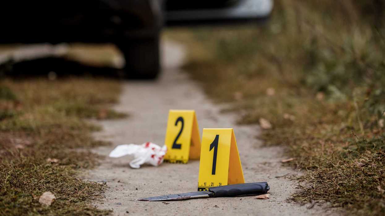 Marcadores de indicio numerados junto a un cuchillo y un pañuelo con manchas rojas sobre un camino de tierra, con un vehículo al fondo, como referencia al ataque armado en Culiacán.