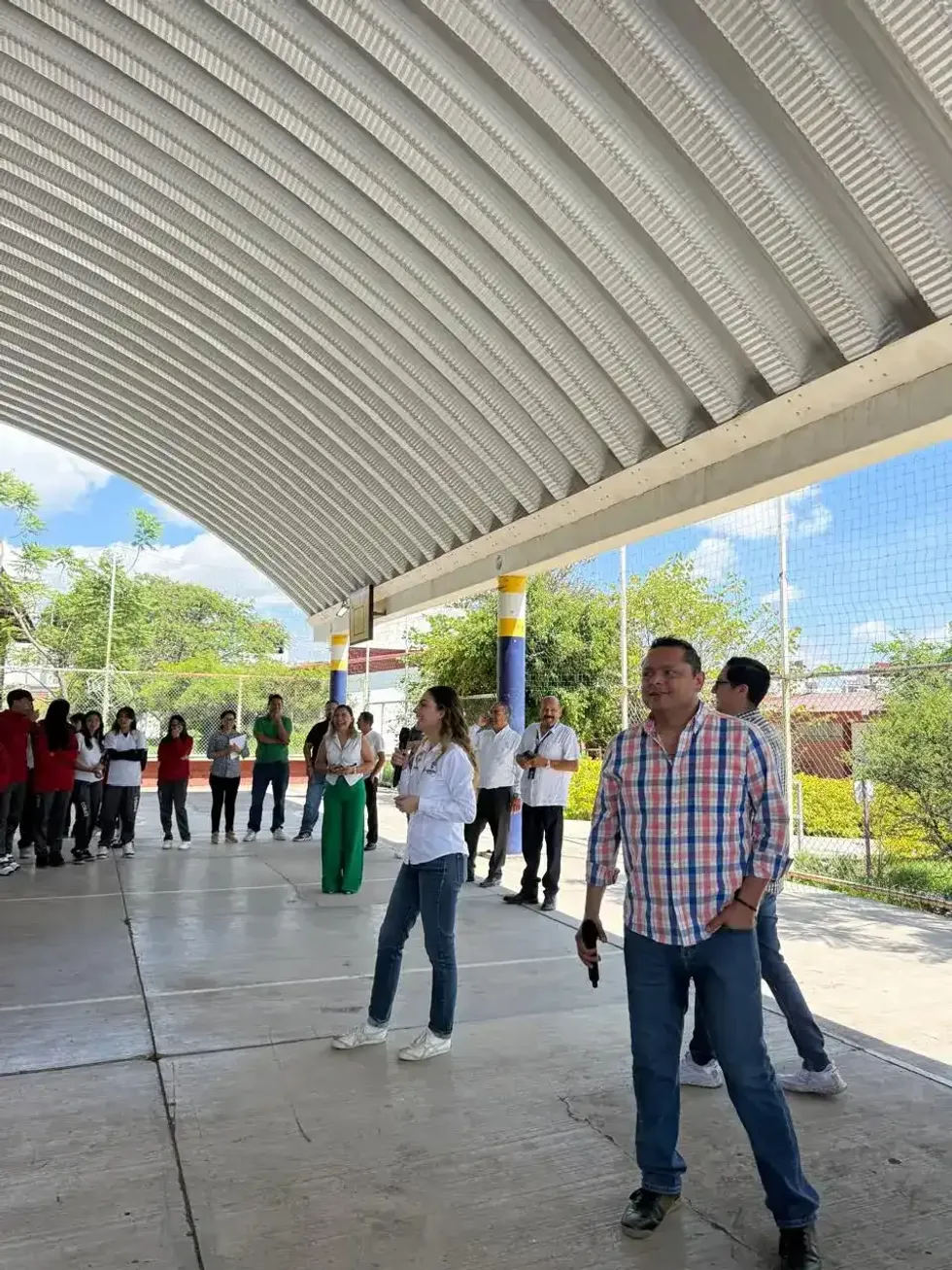 Mariana Ortiz dialoga con estudiantes bajo una lona en un plantel del COBAQ