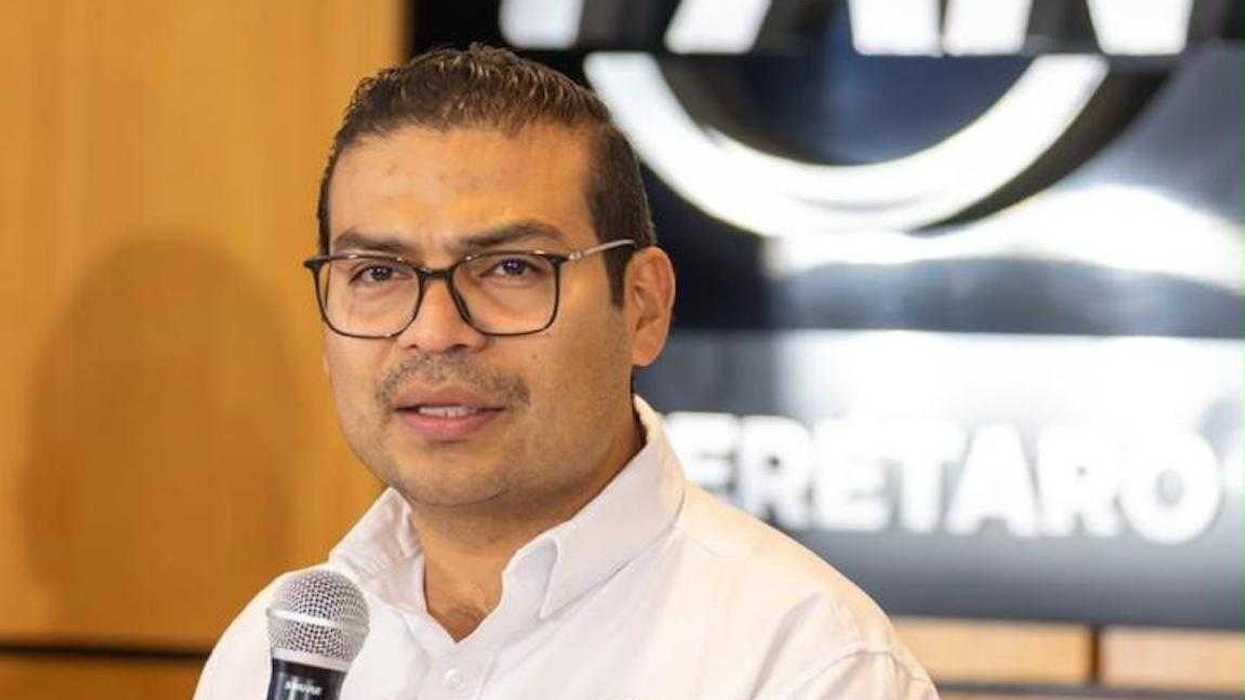 Martín Arango habla con micrófono en mano desde un podio, con el emblema del PAN Querétaro al fondo
