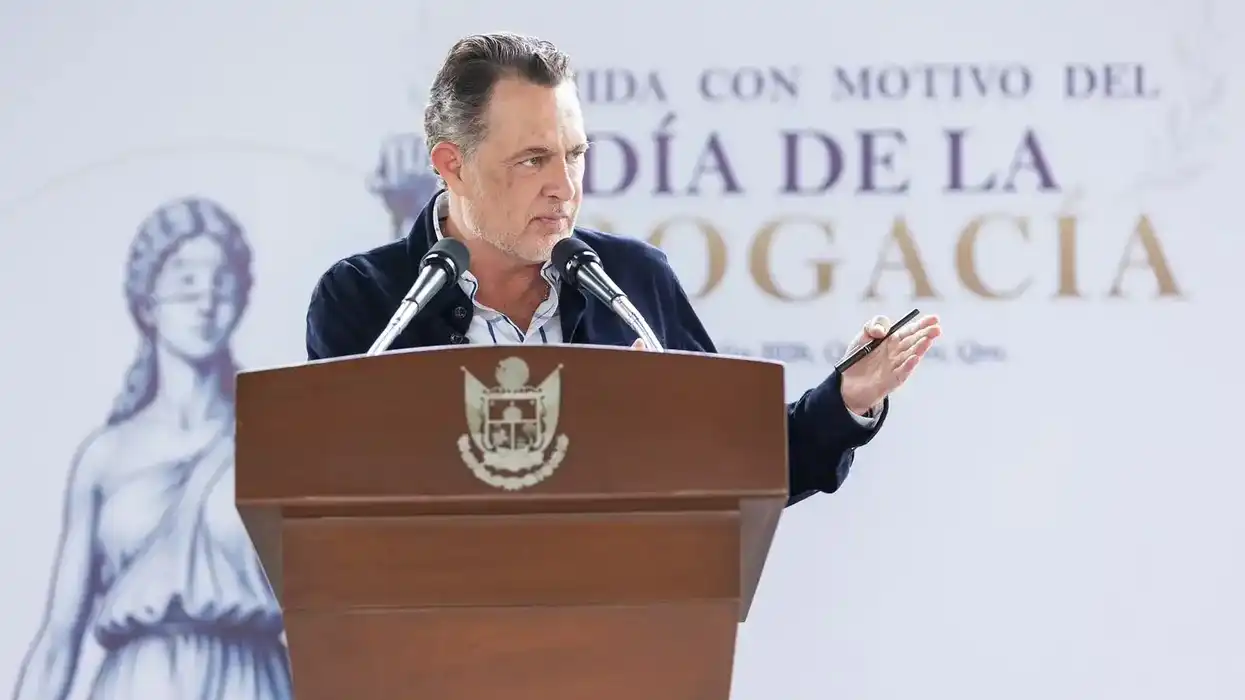 Mauricio Kuri González habla desde un pódium con el escudo de Querétaro