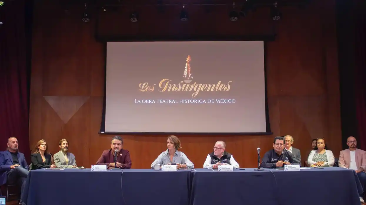 Mesa de presentación de "Los Insurgentes" con logotipo de la obra en pantalla, Querétaro 2026