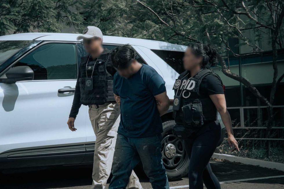 Militares y polic\u00edas caminan junto a un hombre detenido frente a la entrada de un edificio con el emblema de la PID, en la detenci\u00f3n de un requerido por Tabasco.