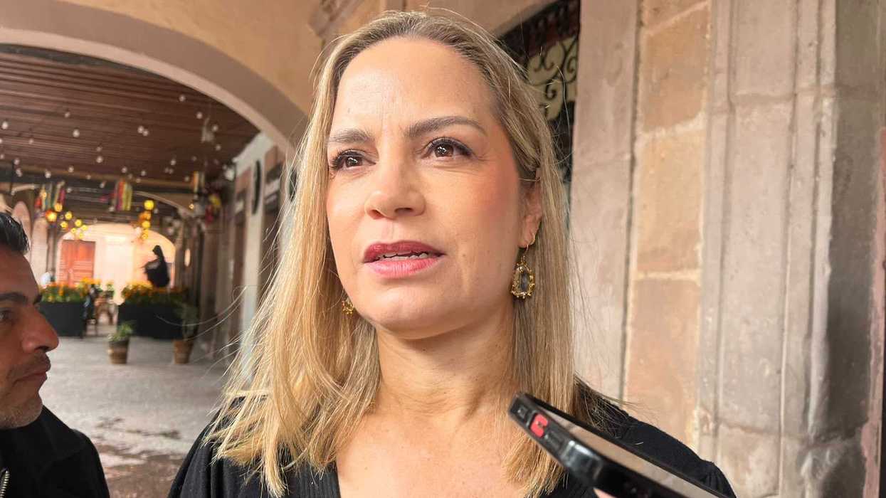 Mujer de suéter negro habla ante un micrófono bajo un portal colonial durante la convocatoria a la Colecta Invernal 2026