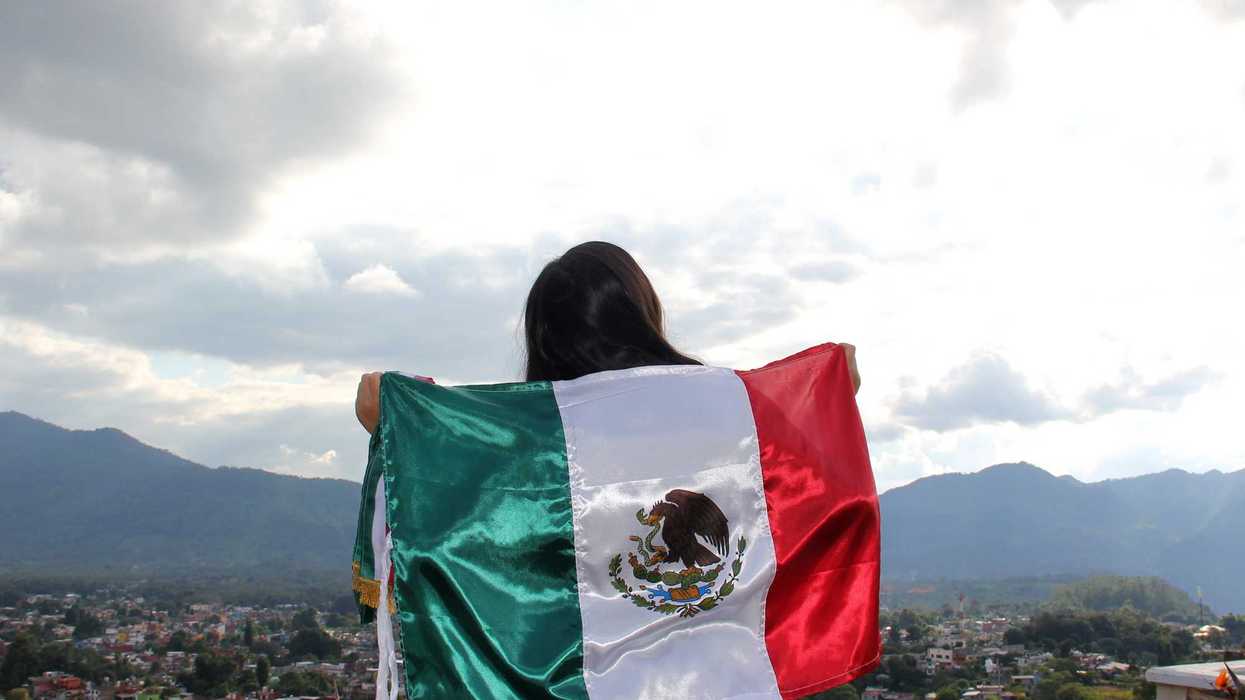 Mujer ondea la bandera de México con vista panorámica de San Juan del Río, en el marco de las Fiestas Patrias 2026