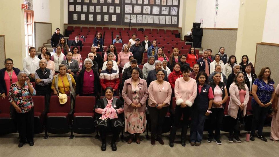 Mujeres con atuendos rosas siguen la conferencia sobre c\u00e1ncer de mama y mastograf\u00eda en San Juan del R\u00edo.