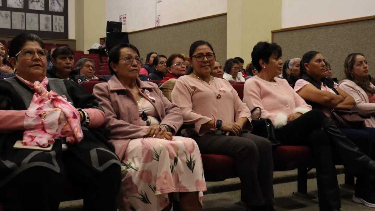 Mujeres con prendas rosas sentadas en las butacas de un auditorio, Mes Rosa y mastografía en San Juan del Río