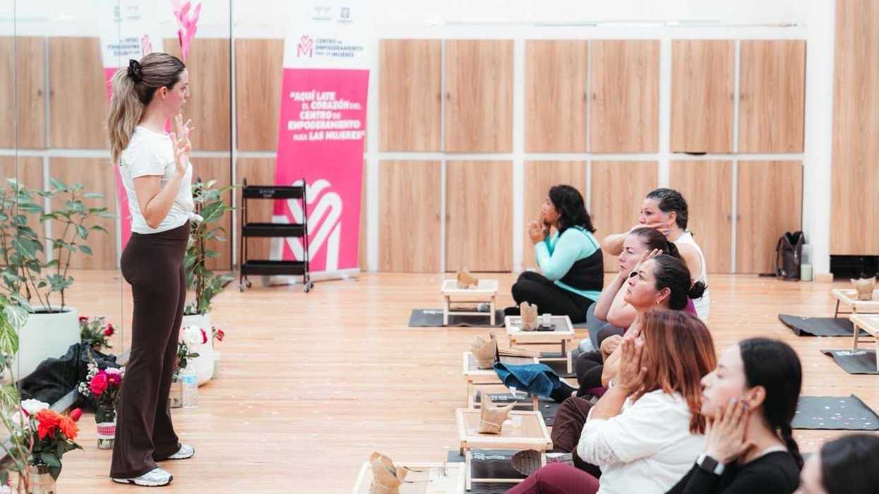 Mujeres sentadas en tapetes realizan un ejercicio con las manos en el rostro en el Centro de Empoderamiento, Querétaro