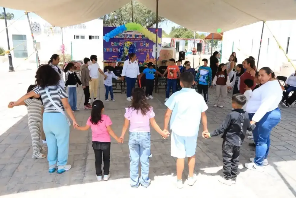 Ni\u00f1as, ni\u00f1os y facilitadoras forman un c\u00edrculo tomados de la mano durante una din\u00e1mica del curso de verano en Col\u00f3n