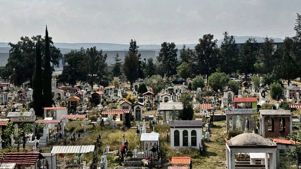Nichos y tumbas de un pante\u00f3n de San Juan del R\u00edo, con \u00e1reas verdes recortadas antes de D\u00eda de Muertos.