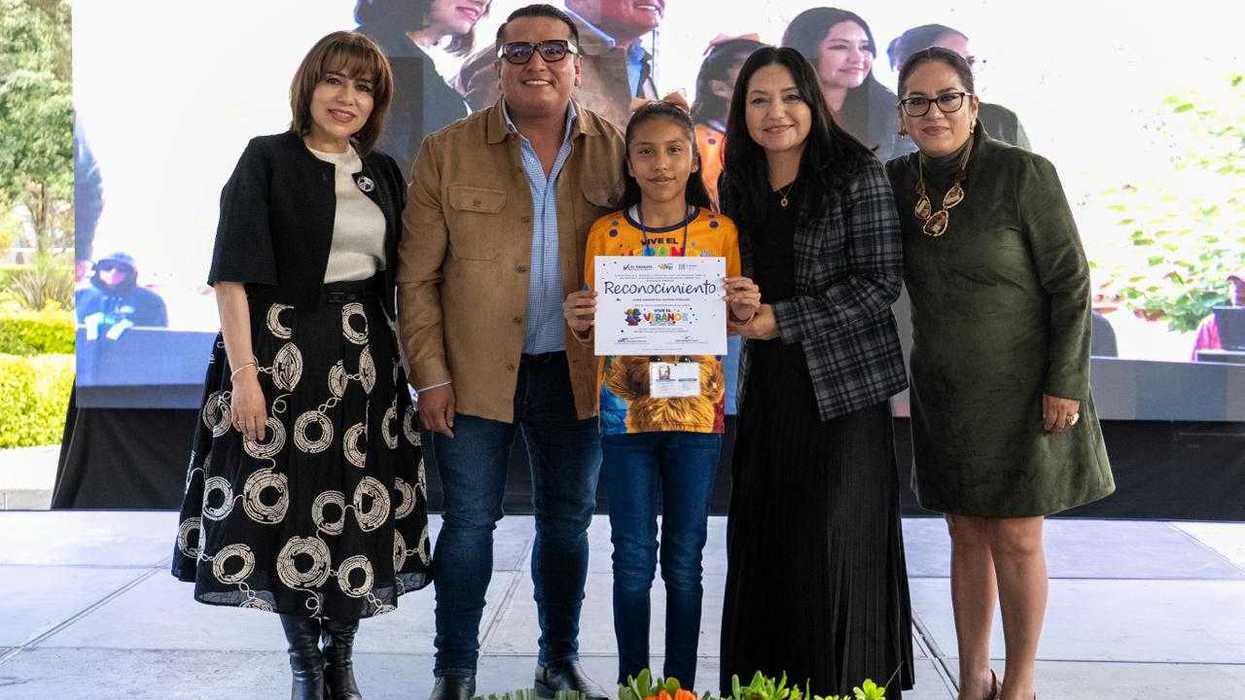 Niño recibe reconocimiento en clausura de Vive el Verano 2026 en El Marqués flanqueado por funcionarios municipales