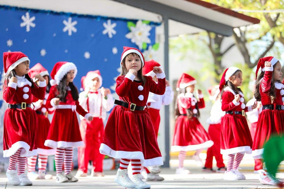 Niños del Centro de Atención Infantil del DIF Querétaro durante presentación de villancicos navideños en inglés con disfraces festivos.