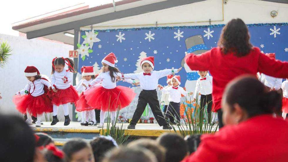 Niños del Centro de Atención Infantil del DIF Querétaro durante presentación de villancicos navideños en inglés con disfraces festivos.