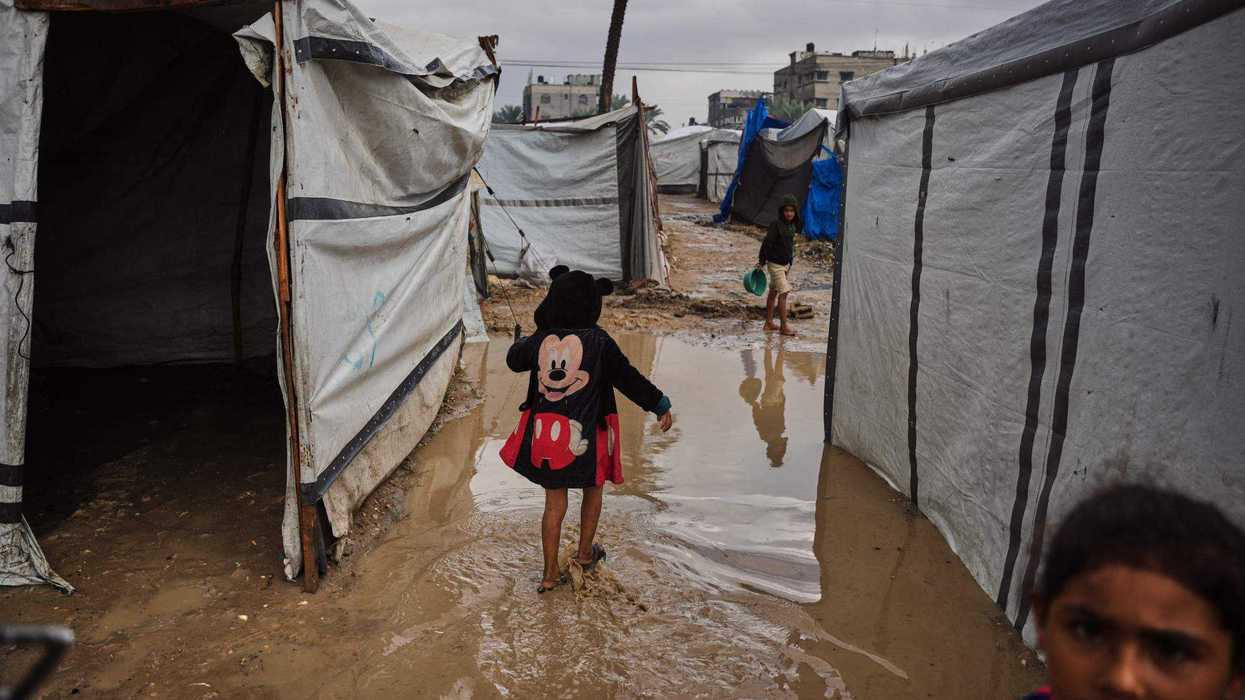 Niños palestinos caminan entre lodo en una zona de tiendas de campaña, luego de una fuerte lluvia en Deir al-Balah, Franja de Gaza, el 25 de noviembre de 2025. AP.